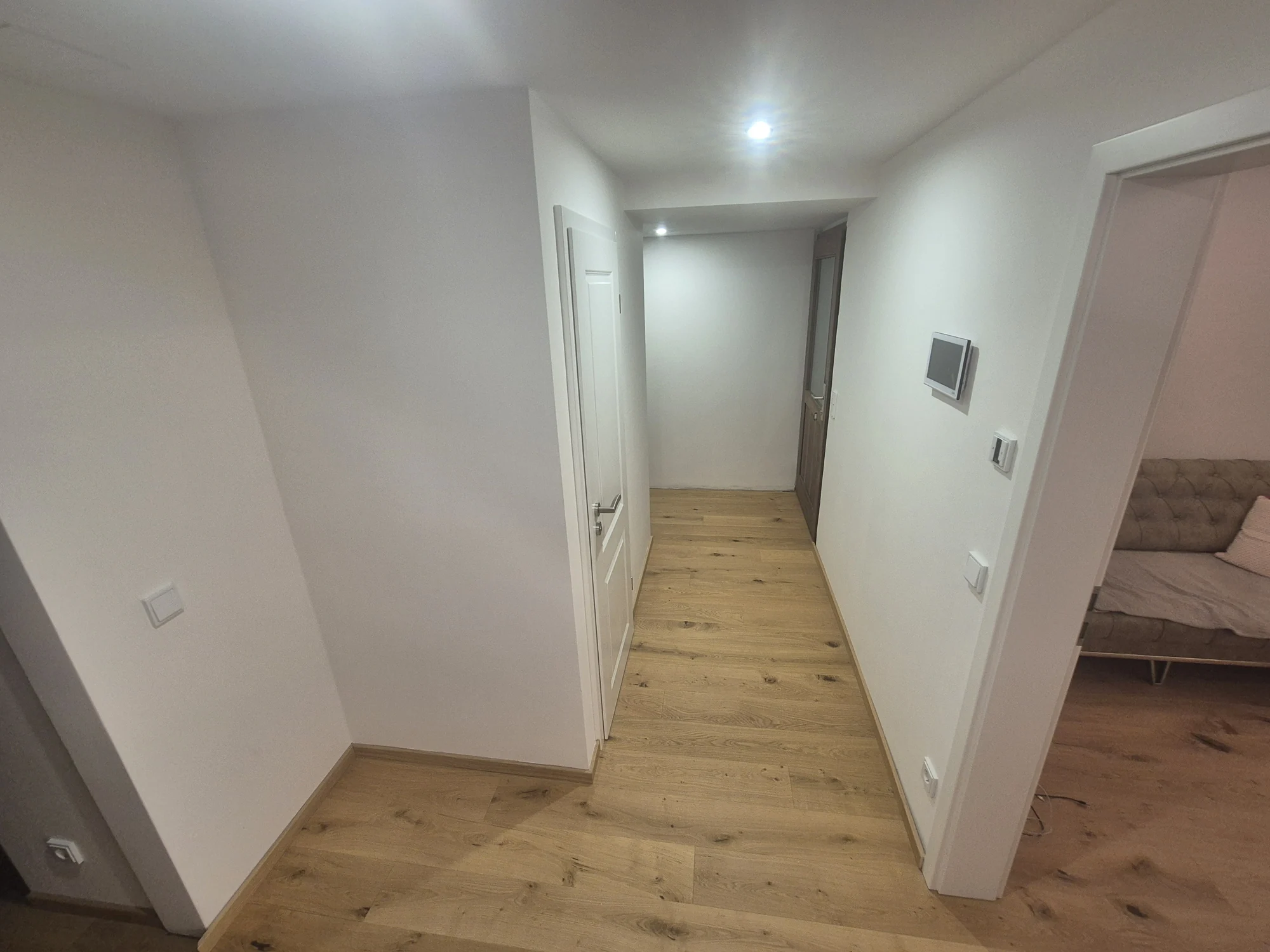 Sanierter Wohnungsflur mit Holzboden und weißen Türen – Mesret Bau